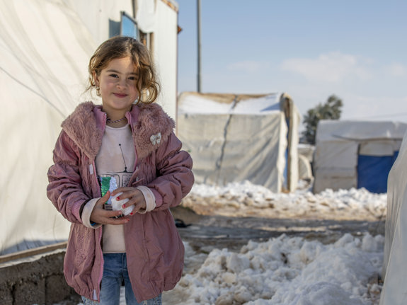 UNHCR-personal skakar hand framför en försändelse med nödhjälp.