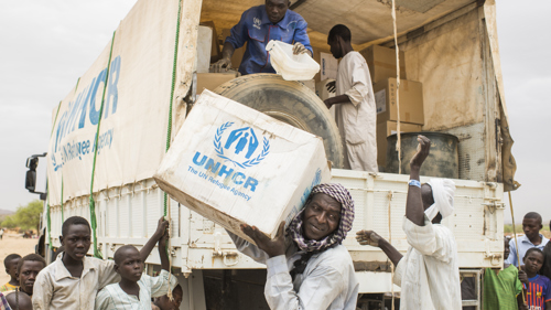 Två personer står med ryggen mot kameran, en är UNHCR:s fältpersonal, efter jordbävningen i Turkiet och Syrien 2023.