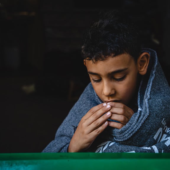 En syrisk pojke insvept i varm filt.