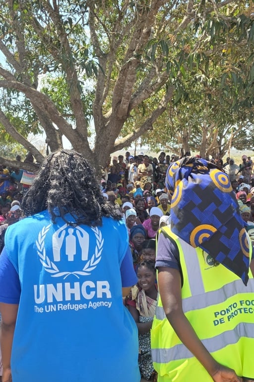 Hjälparbetare från UNHCR pratar med en folkmassa i Mocambique.