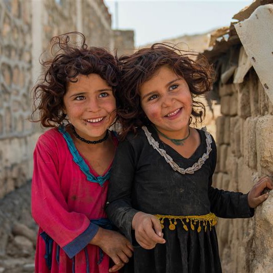 Två flickor ler in i kameran.