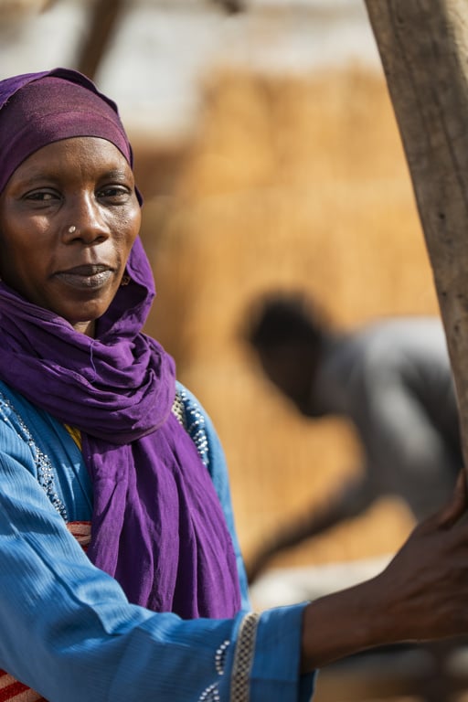 En sudanesisk kvinna. Hon tittar in i kameran och ser allvarsam ut.