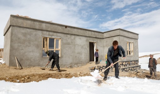 En familj skottar snö framför sitt hus