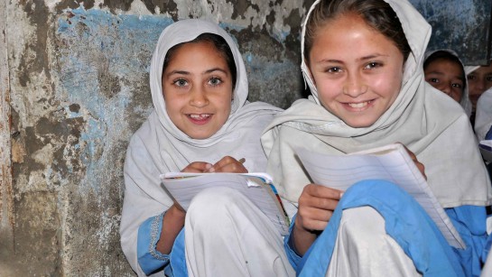 Två flickor från Afghanistan har fått skolpaket och möjlighet att gå i skolan - som de älskar.