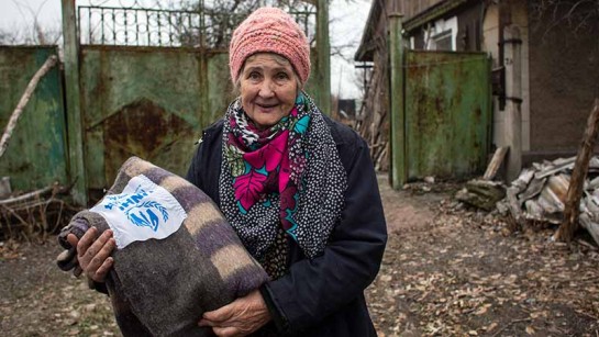 Klavdia Beliakova som bor i östra Ukraina har fått en filt av UNHCR. Många som är kvar är kvar är äldre och extra utsatta. 